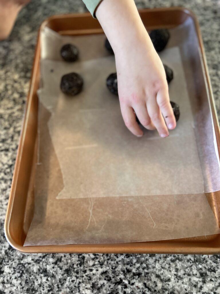 Placing oreo cookie balls on cookie sheet