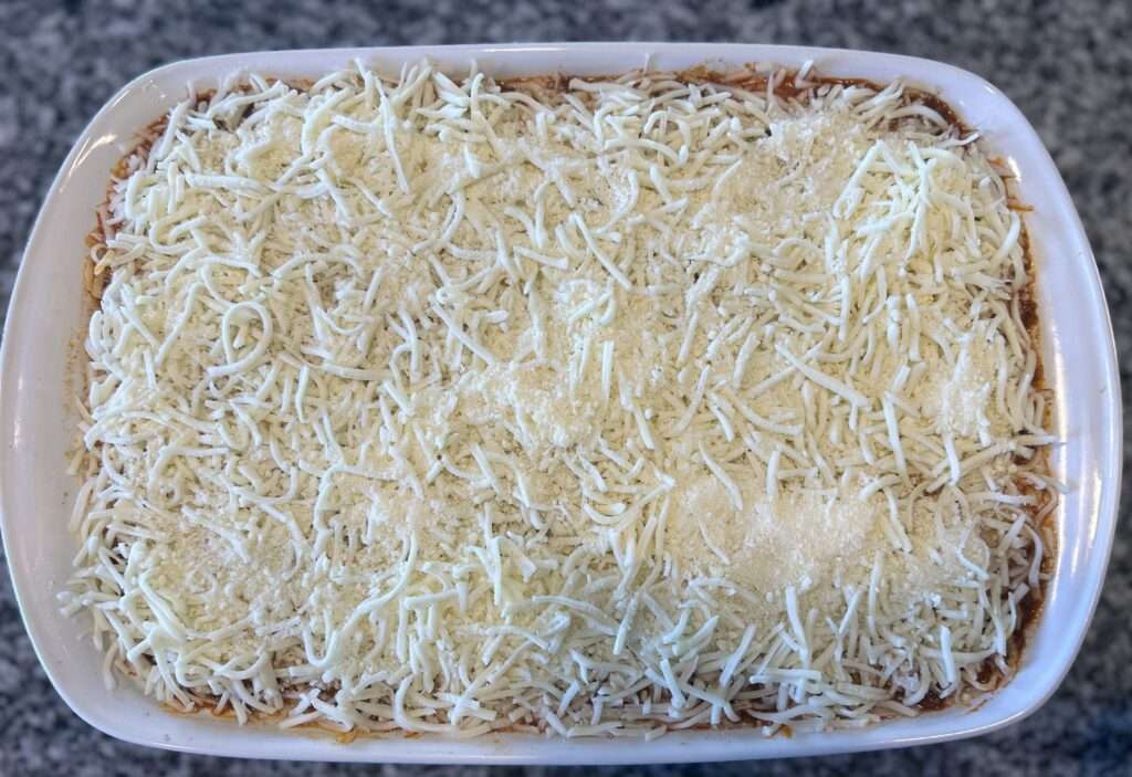A full pan of lasagna with bolognese sauce ready to go in the oven.