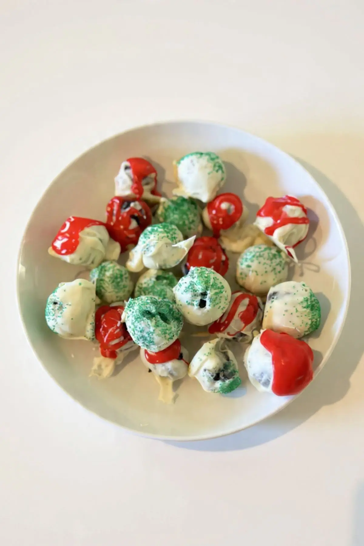 Christmas Oreo truffles with white chocolate, red drizzle and green sprinkles