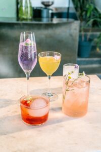 A collection of various wine cocktails on a table outside.