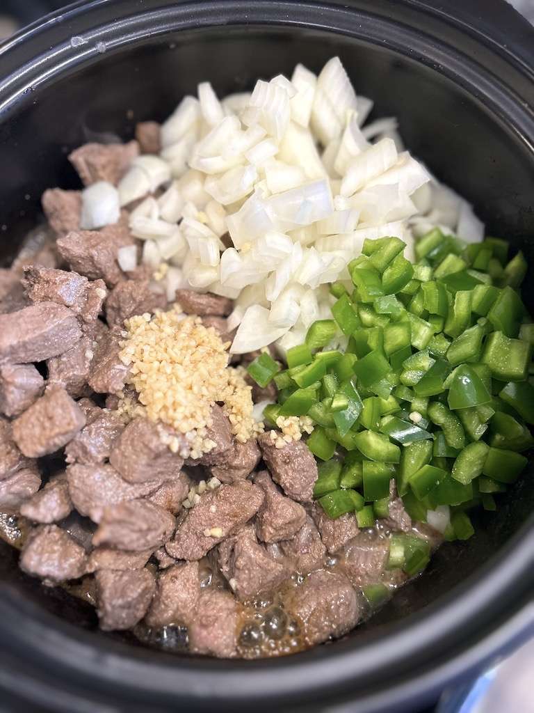 Add the onions, jalapeños and garlic to the browned beef in the dutch oven to make beef chimichangas.