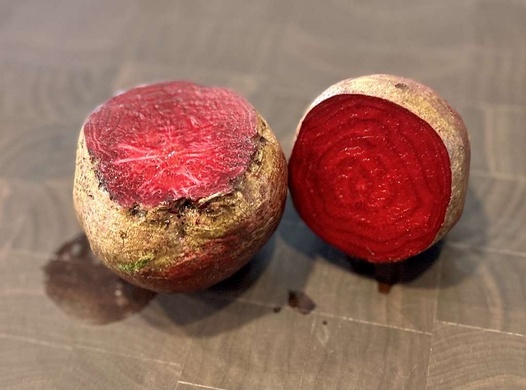 Beet roots cut in half showing the bright red inside.