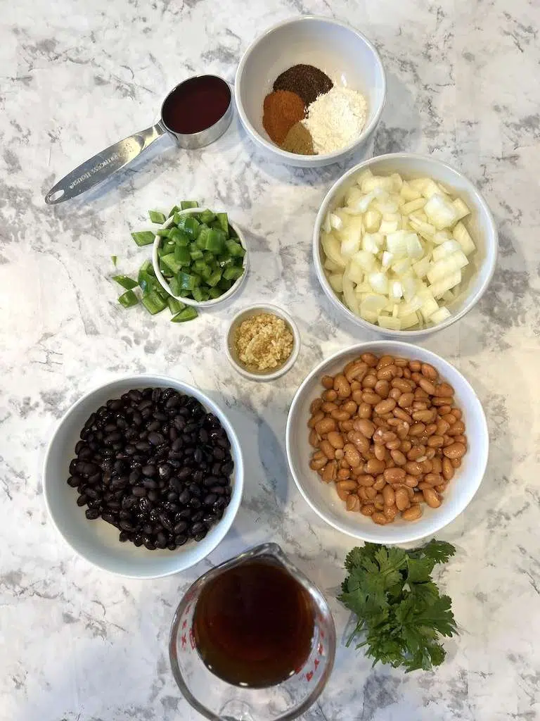 The ingrerdeints for shredded beef chiimichangas including onions, seasonings, jalapenos, beans and beef broth.