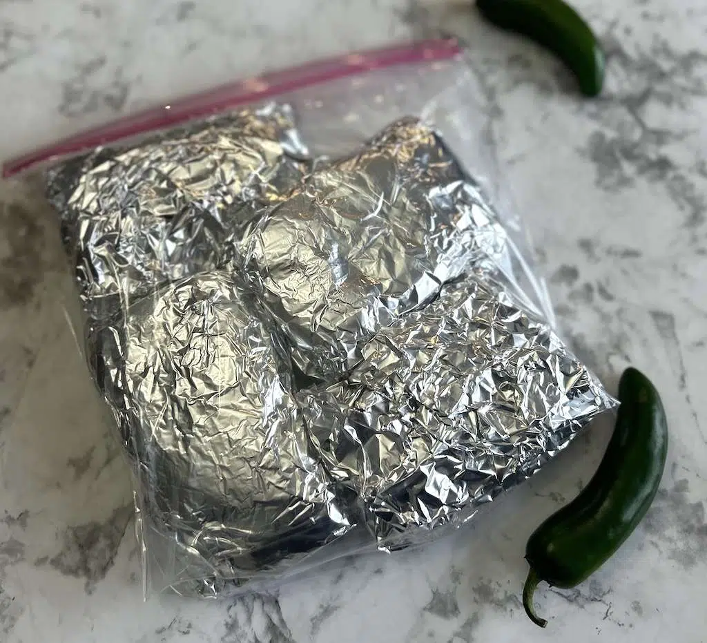 Chimichangas individually wrapped in tin foil for freezing.