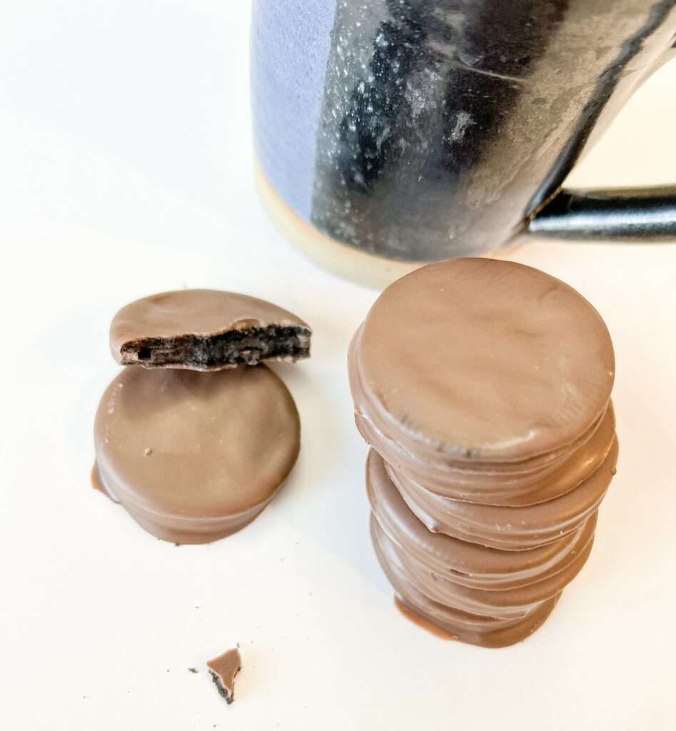 A stack of homemade Oreo Thin Mint cookies next to a blue mug.