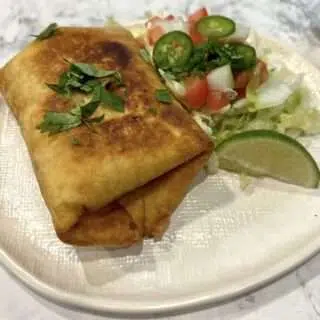 Plated Chimichangas with toppings.