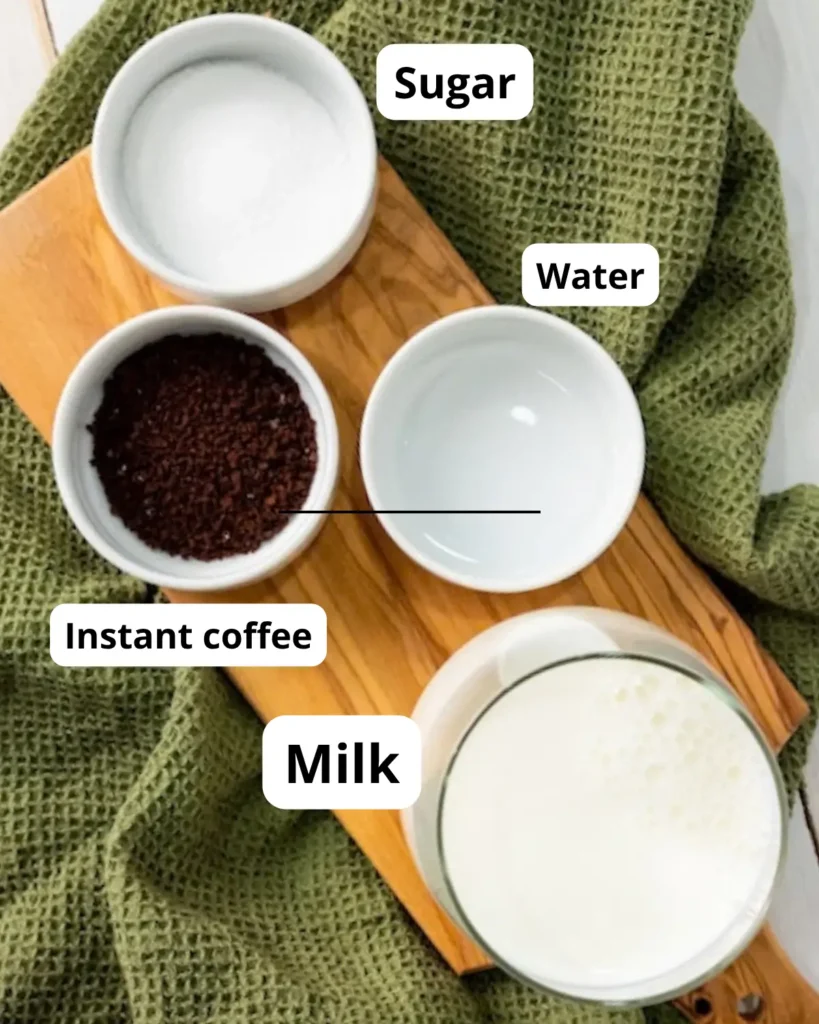 Ingredients for Dalgona Latte: sugar, instant coffee, water, milk on a wooden board