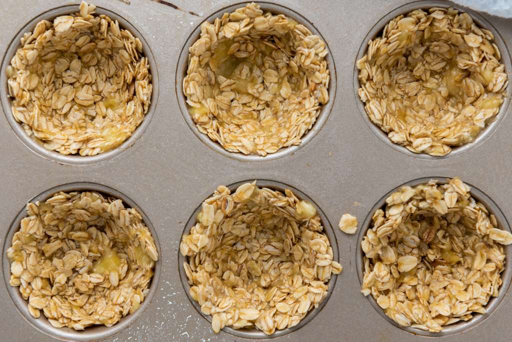 Granola mixture in a muffin tin to create mini granola cups.