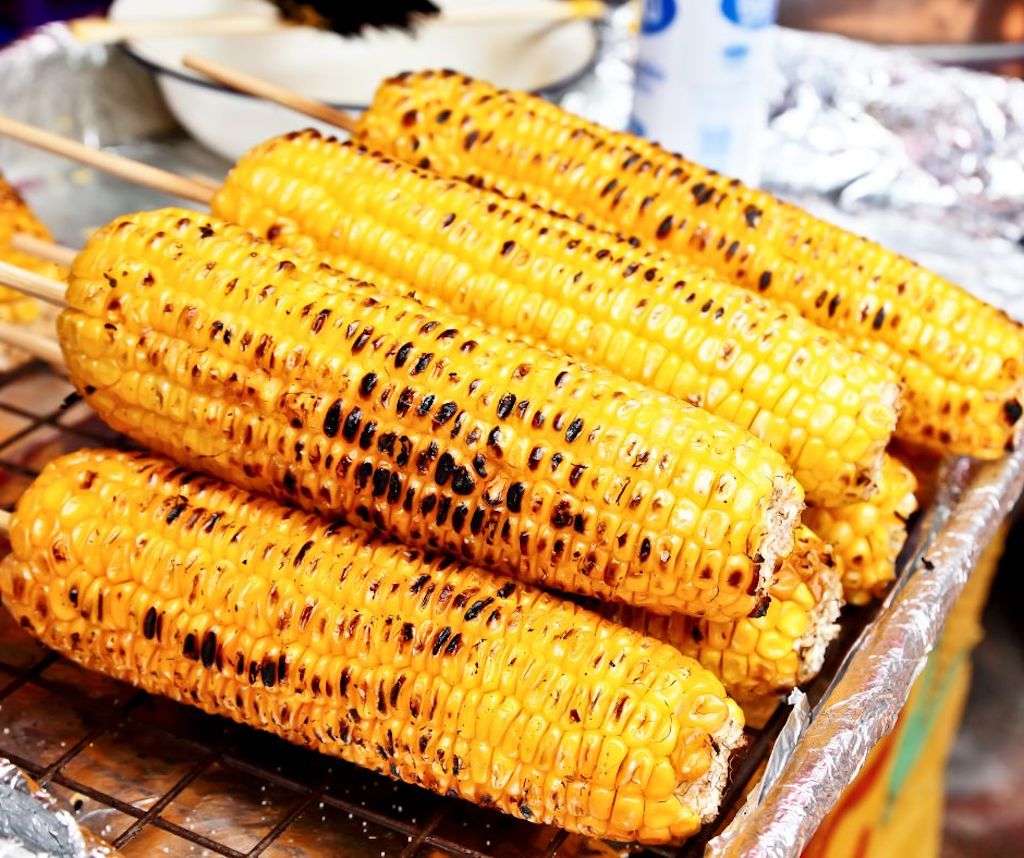 Grilled Corn on the Cob on a tin foil lined cookie sheet.