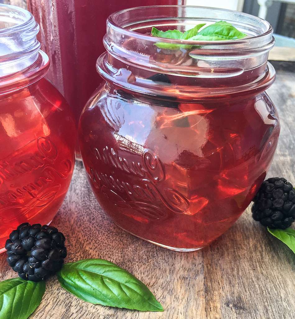 Glass of Instant Pot blackberry iced tea garnished with fresh basil