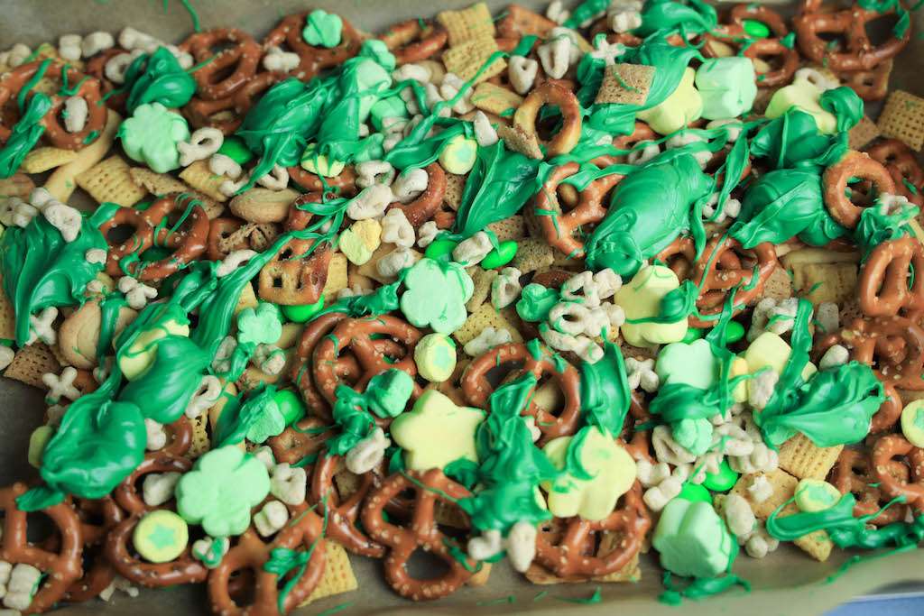 The leprechaun bait on a parchment lined cookie sheet with the melted green candies drizzled over the top.