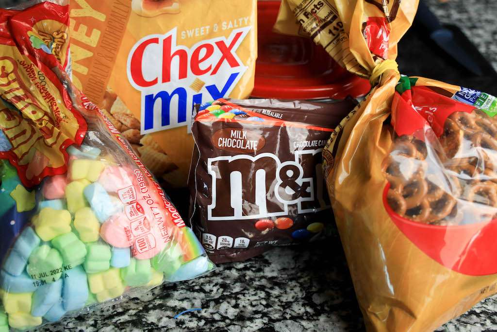 Leprechaun bait ingredients including a bag of Mu0026M's, pretzels, chex mix and marshmallows.