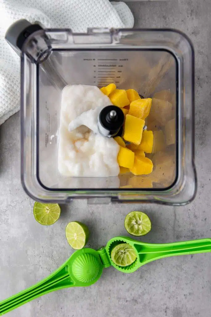 Delicious Tropical Mango Coconut Lime Popsicle Recipe Mango Coconut Lime - yogurt and mango in the blender with juiced limes.