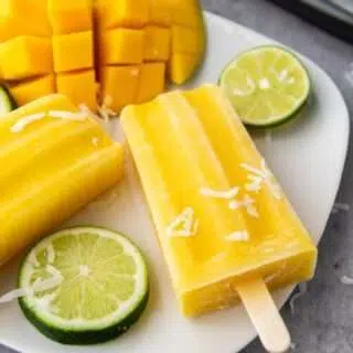 Delicious Tropical Mango Coconut Lime Popsicle Recipe Mango Lime Popsicles on a plate