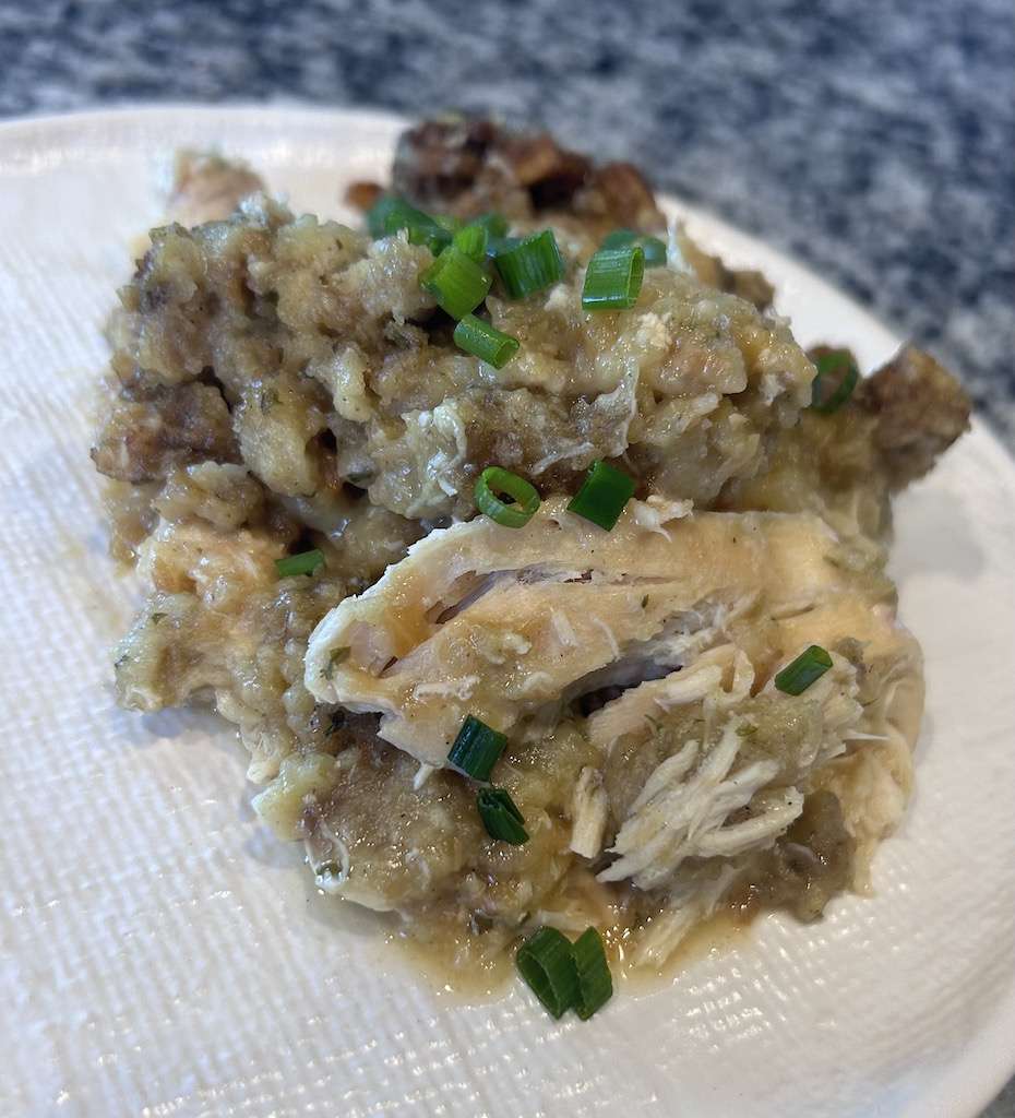 chicken and stuffing on a plate garnished with fresh chives.