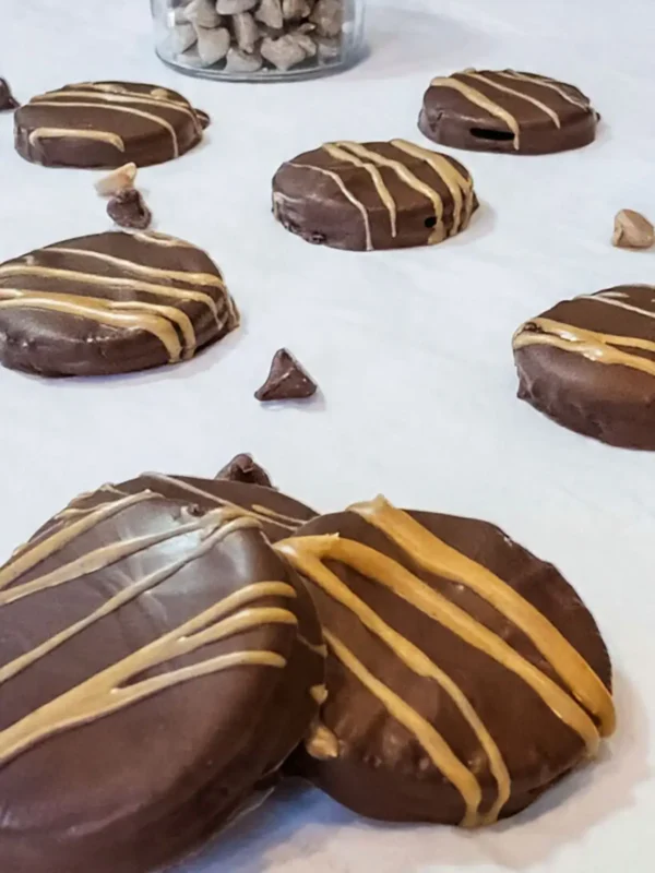 Chocolate-covered peanut butter sandwich cookies with drizzle