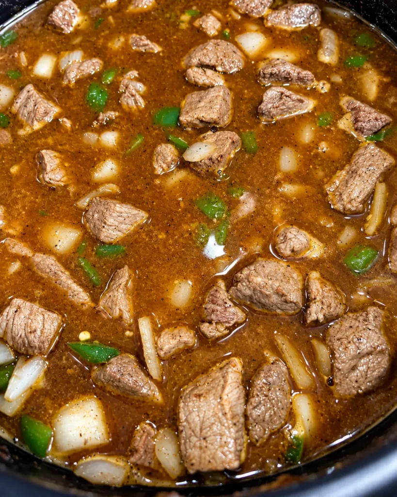 Cooking shredded beef and vegetables in rich broth for chimichangas