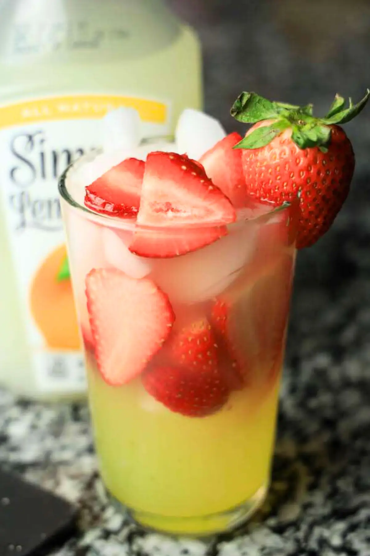 Refreshing iced strawberry lemonade in a glass with fresh slices and garnish