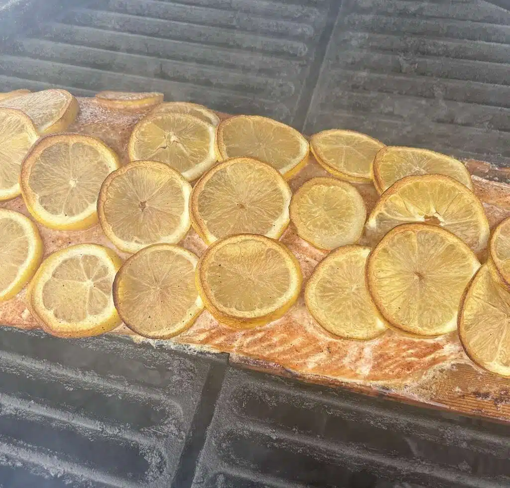 A close up view of a Kamado Joe cedar planked salmon on the grill.