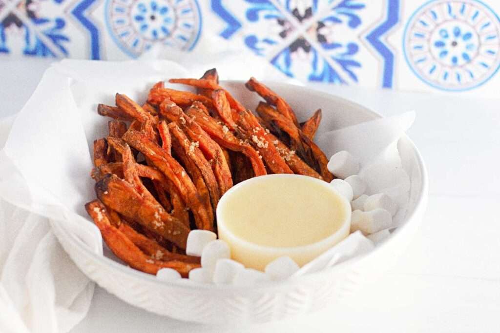 10 Delicious Side Dishes to Serve with French Dip Sandwiches Crispy sweet potato fries with aioli dip in a white bowl