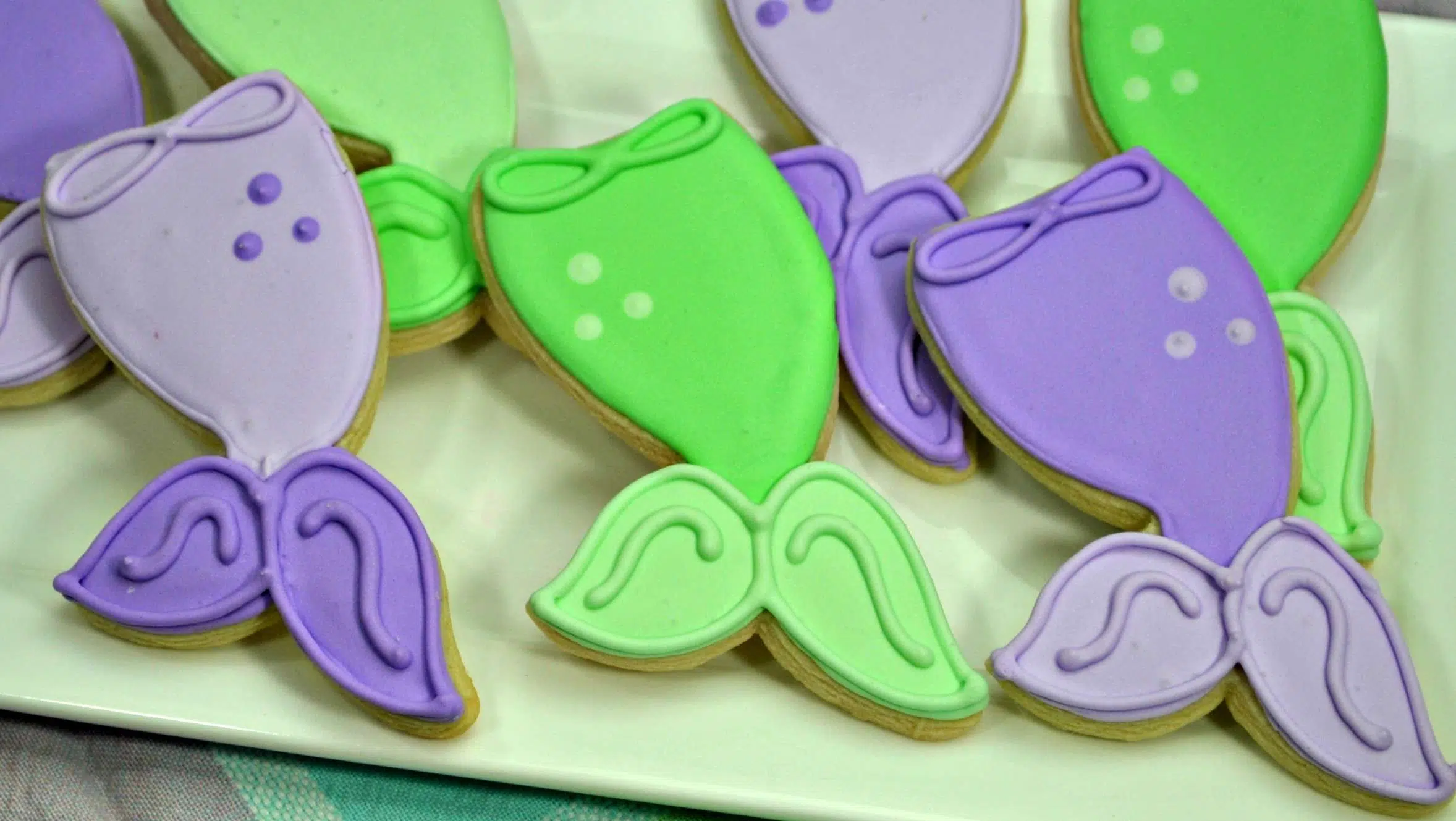 Purple and green mermaid tail sugar cookies with royal icing