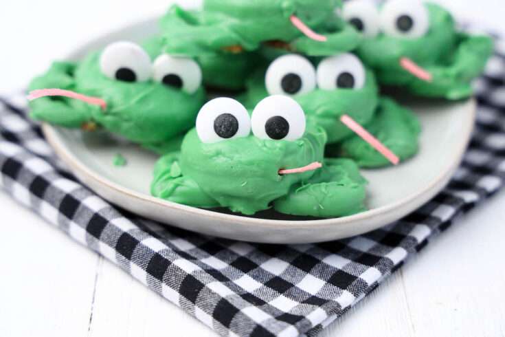 Oreo frog cookies on a plate on a black and white checkered napkin