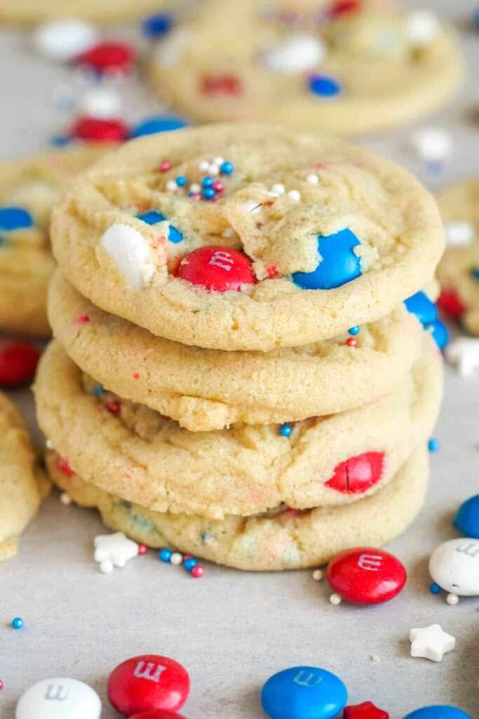 Patriotic M&M sugar cookies stacked with red, white and blue sprinkles