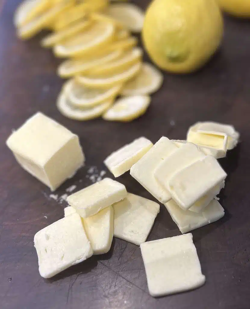 Sliced butter and lemons for topping the cedar planked salmon.