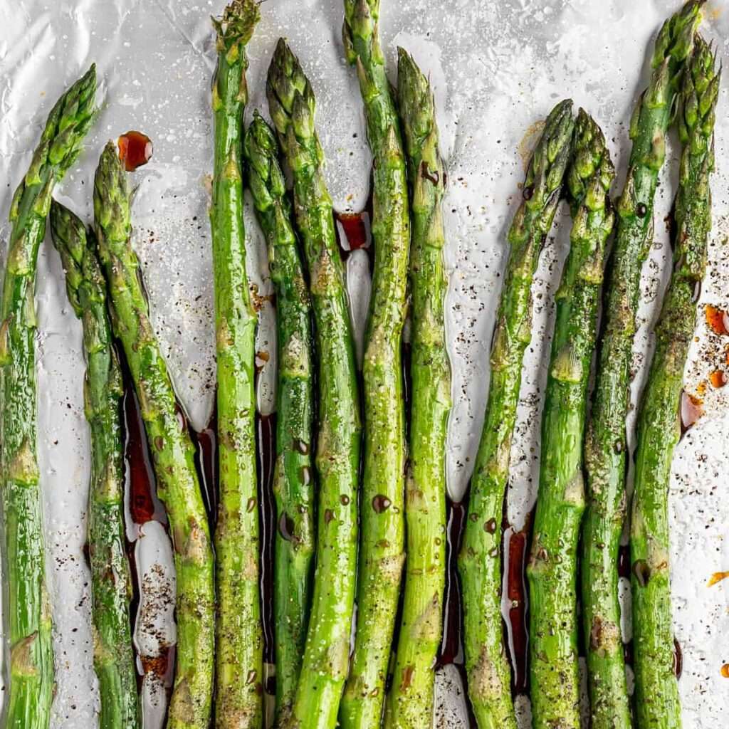Balsamic glazed asparagus on a marble background.
