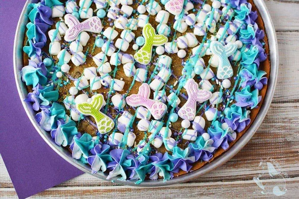 Mermaid tail cookie cake with teal and purple frosting and sprinkles