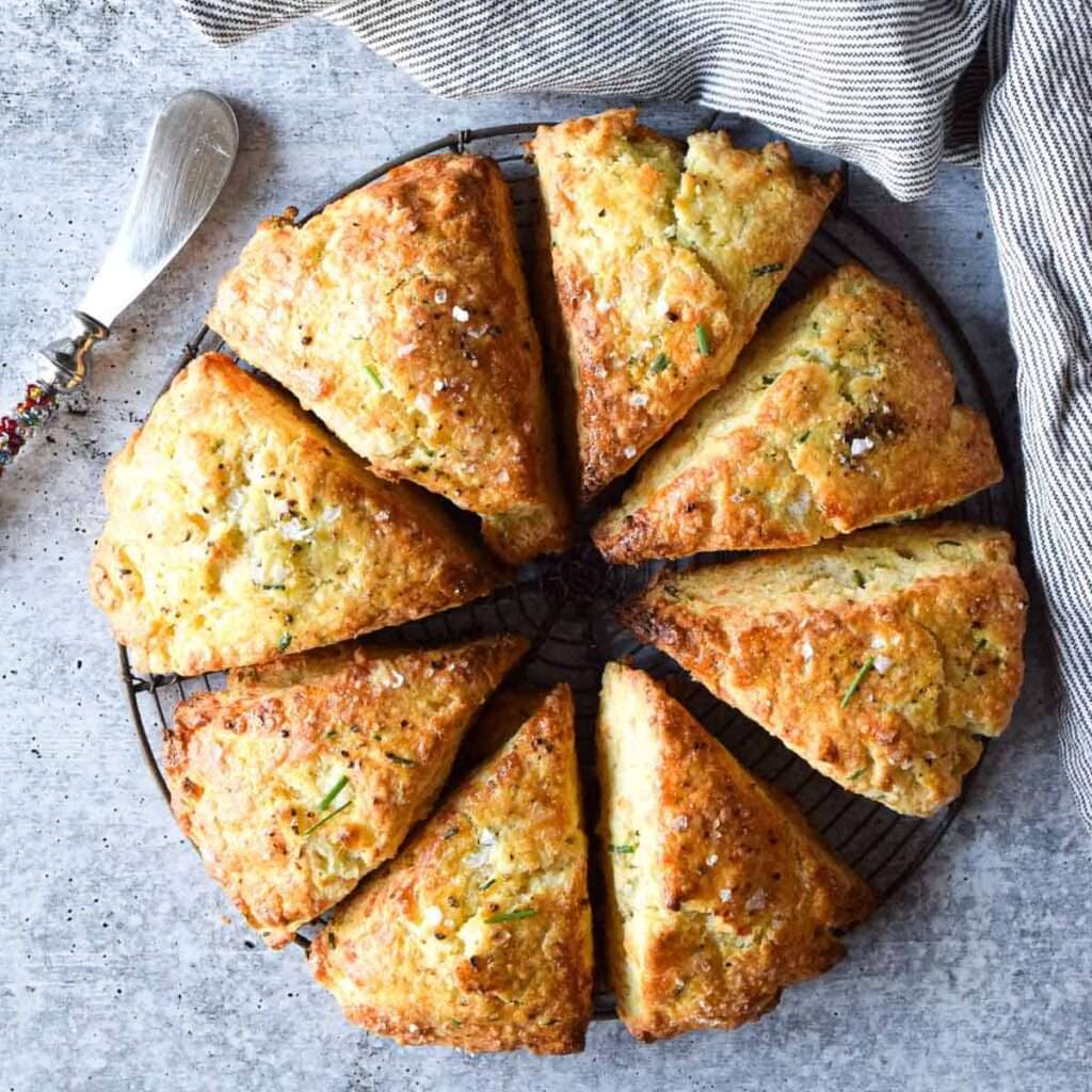 Golden cheddar chive scones on a cooling rack