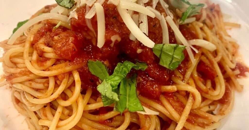 10 minute Marinara over spaghetti noodles with fresh grated parmesan cheese and fresh chopped basil.