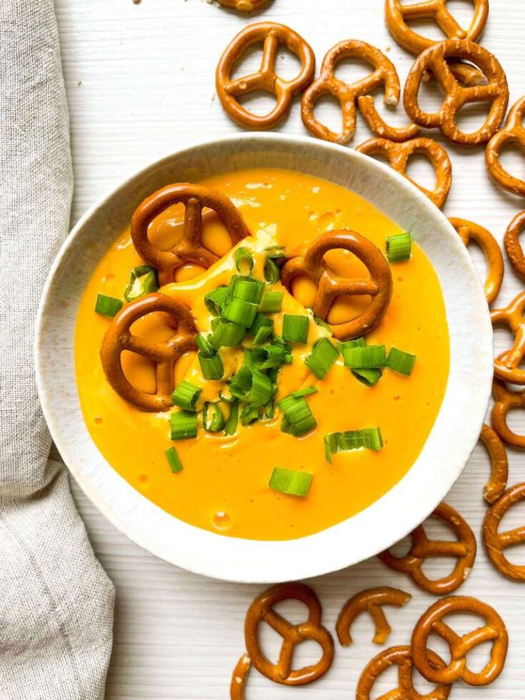 Hot Beer Cheese Dip with green onions and pretzels
