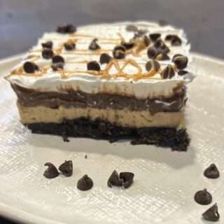 Slice of Chocolate Peanut Butter Lasagna on a white plate.