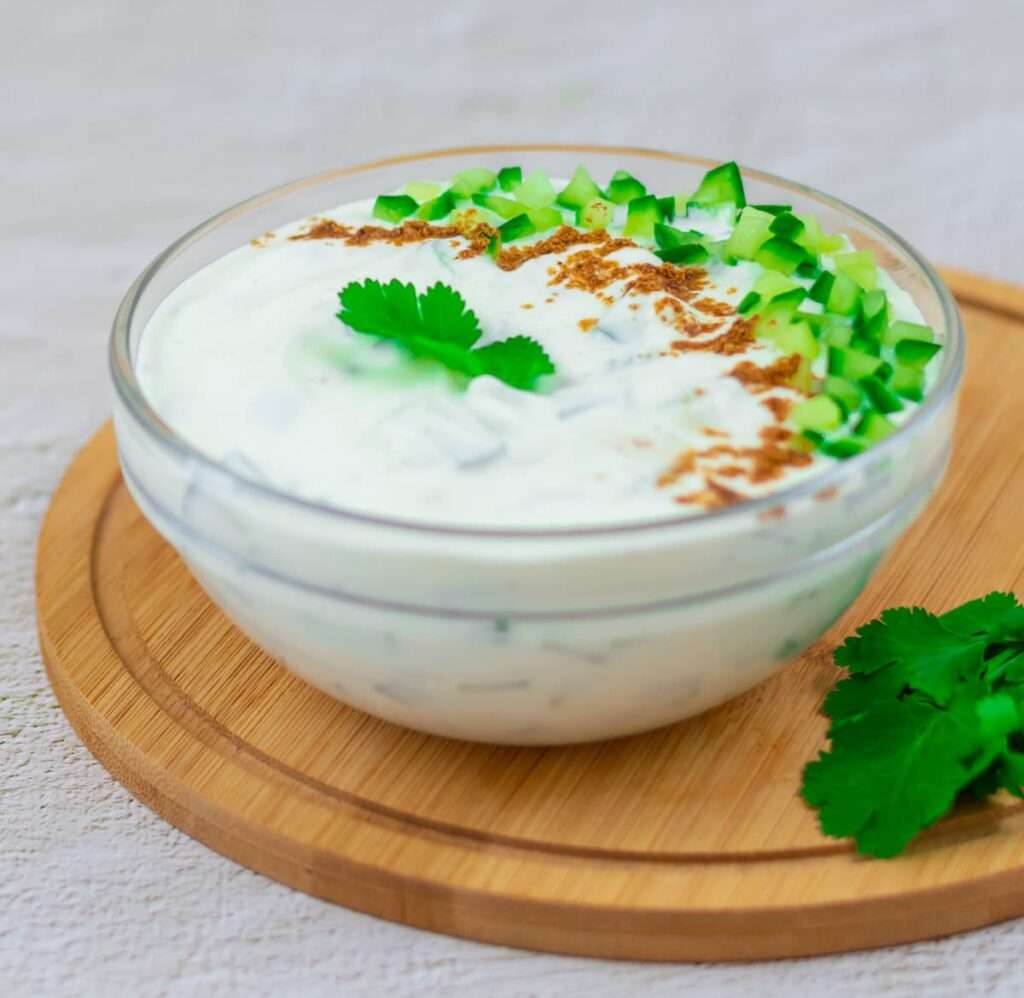 10 Fun Facts About Cucumbers Cucumber raita yogurt dip with cumin and cilantro in a glass bowl