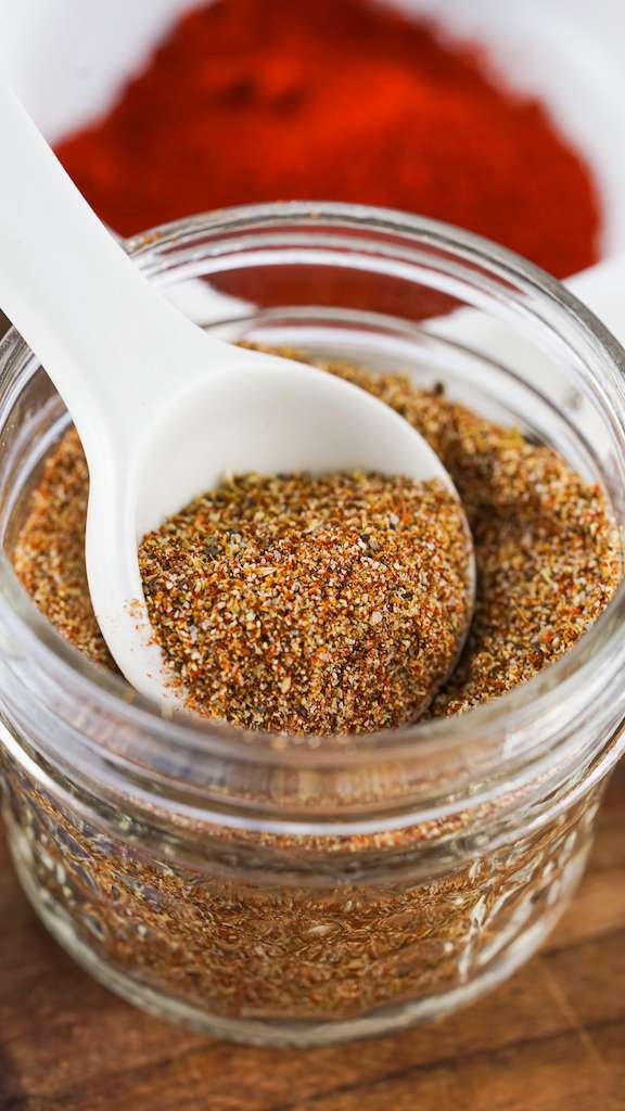 Homemade taco seasoning in a small mason jar with a spoon.