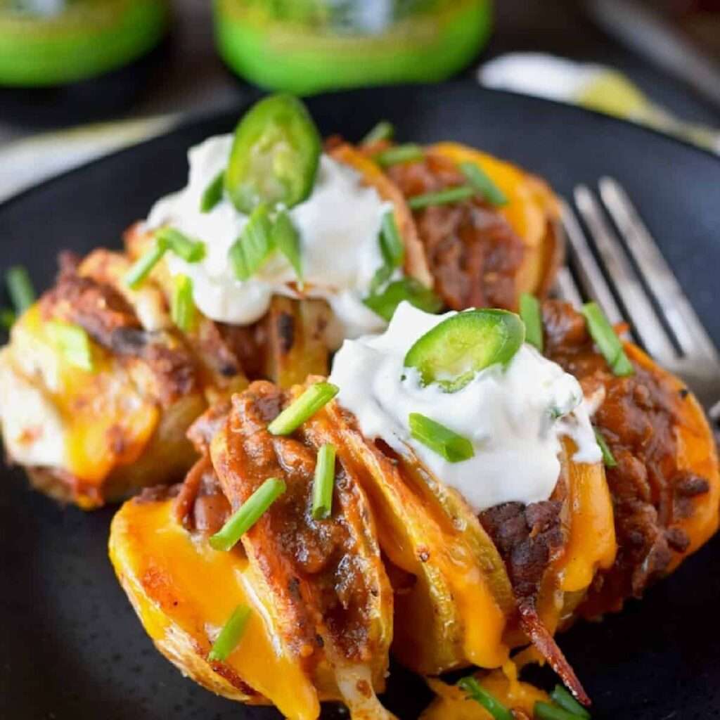 12 Creative Leftover Chili Recipes Loaded Hasselback potatoes with chili, melted cheddar, sour cream, jalapeno, and scallions
