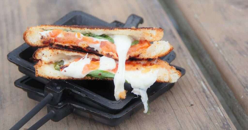 13 Pie Iron Recipes - Sweet & Savory Caprese grilled cheese sandwich with melty mozzarella in a campfire pie iron