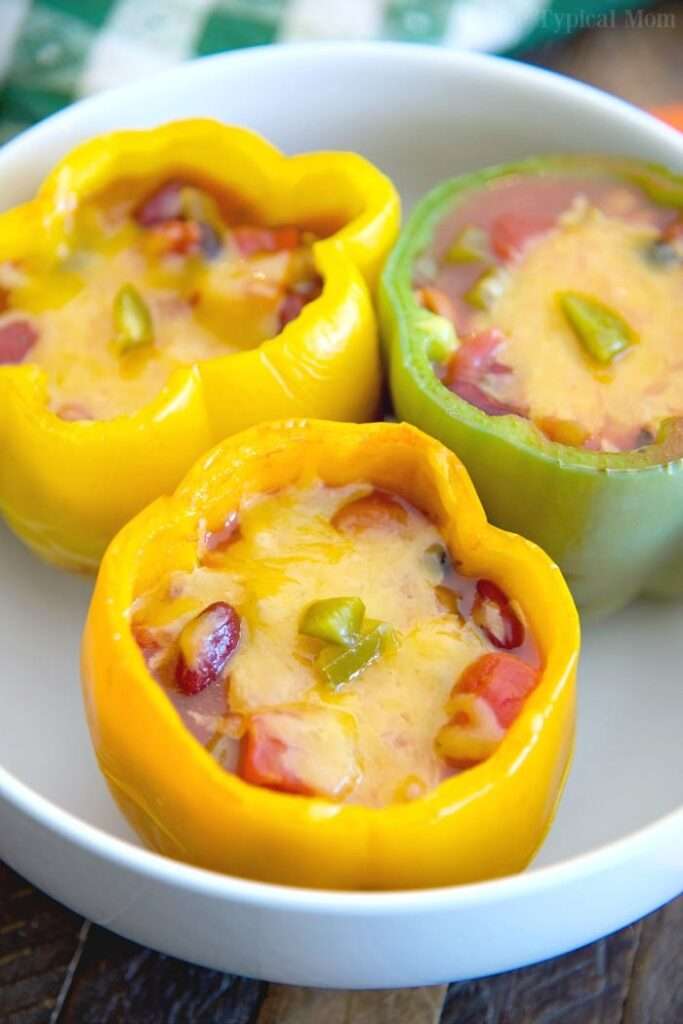 12 Creative Leftover Chili Recipes Cheesy stuffed bell peppers with beans and veggies in a white bowl