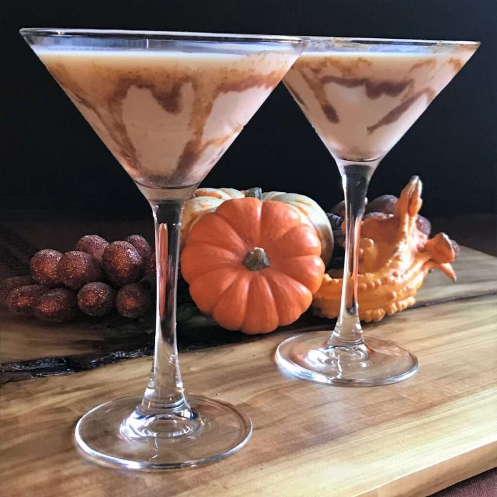 11 Delicious Pumpkin Cocktails to Try This Fall Creamy pumpkin spice martinis with caramel swirl, autumn pumpkins and gourds on wood