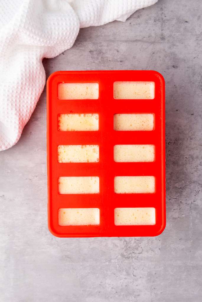 The wine popsicle mixture poured into the popsicle molds.