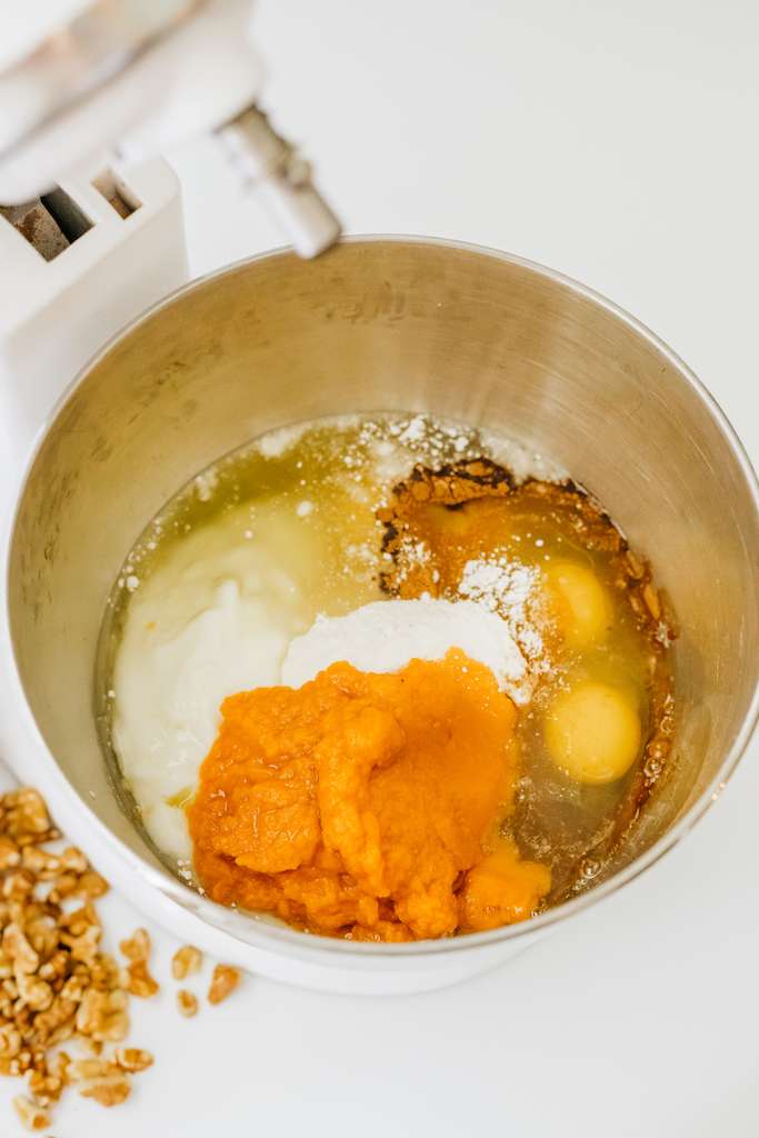 Ingredients for the pumpkin honey bun cake in a standing mixer.