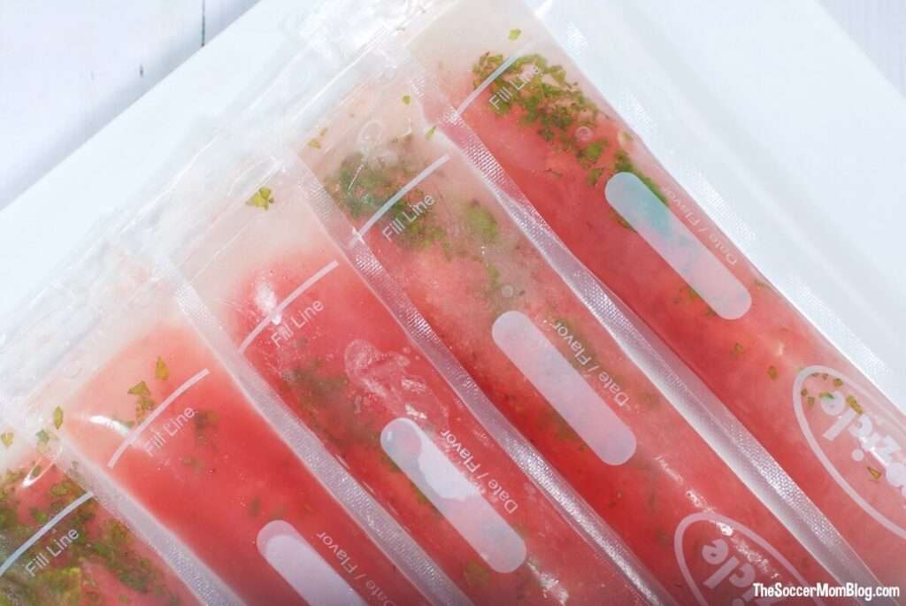 7 Delicious Wine Popsicle Recipes to Try This Summer Homemade fruit popsicles with mint in plastic freezer sleeves