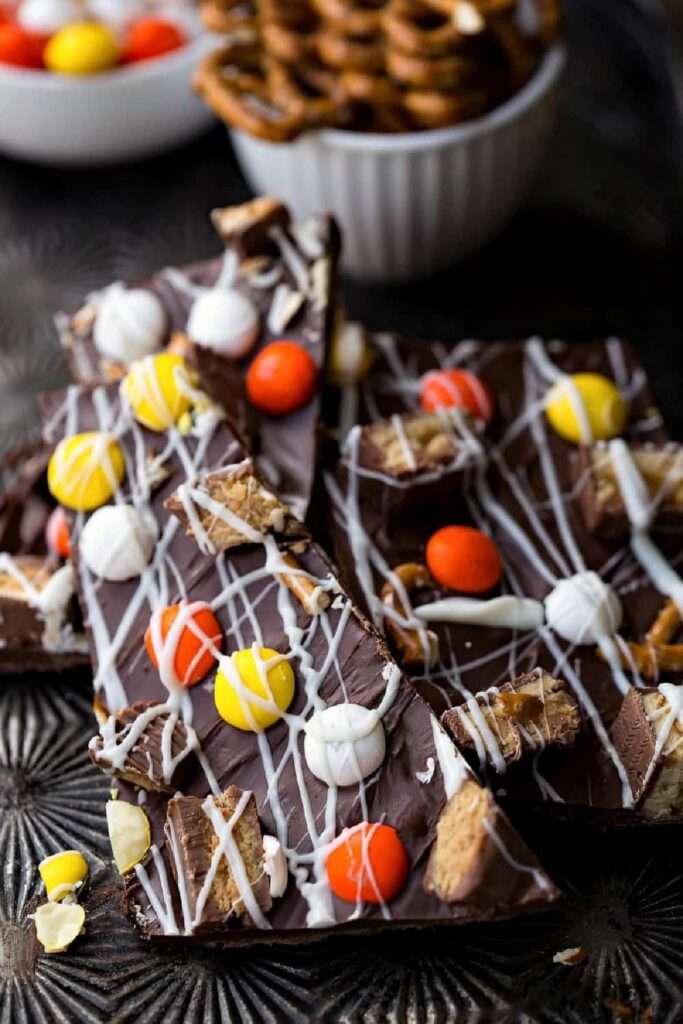 16 Easy & Spooky No Bake Halloween Treats Dark chocolate bark with pretzels, candy, and white drizzle