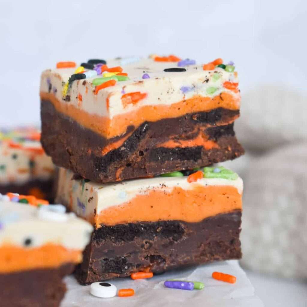 16 Easy & Spooky No Bake Halloween Treats Stacked Halloween fudge brownie bars with orange layers and sprinkles