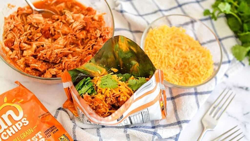 14 Walking Recipes Perfect for Camping Walking taco in chip bag with shredded chicken, cheese, and cilantro.