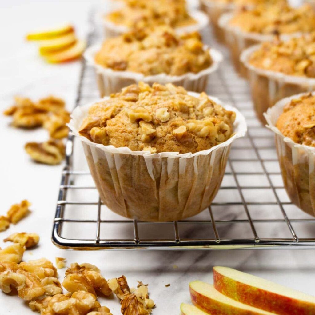 Fresh-baked apple walnut muffins on a cooling rack