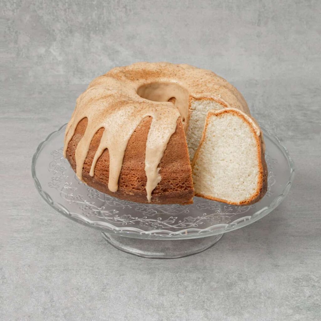 8 Traditional Christmas Flavors Sliced vanilla bundt cake with cinnamon glaze on a glass cake stand