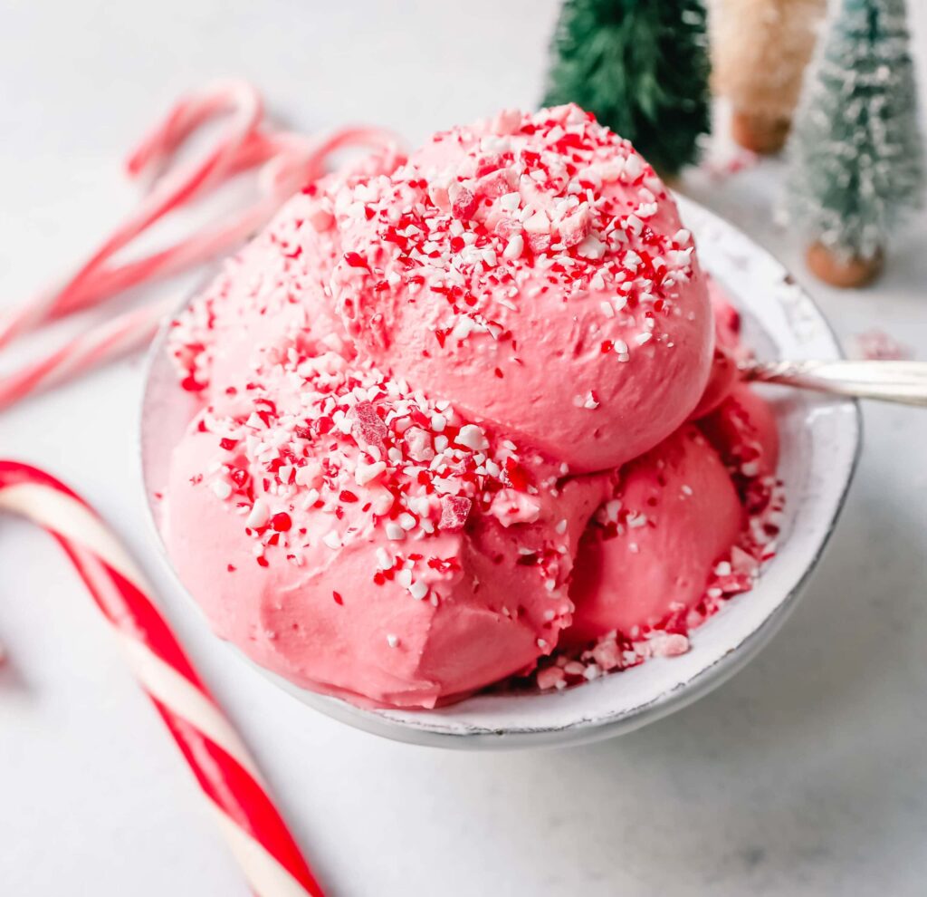 8 Traditional Christmas Flavors Pink peppermint ice cream scoops in a bowl with crushed candy canes