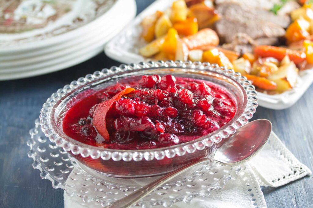 8 Traditional Christmas Flavors Homemade cranberry sauce with orange zest in a glass serving bowl